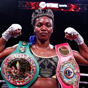 Claressa Shields boxer holding title belts with a crown