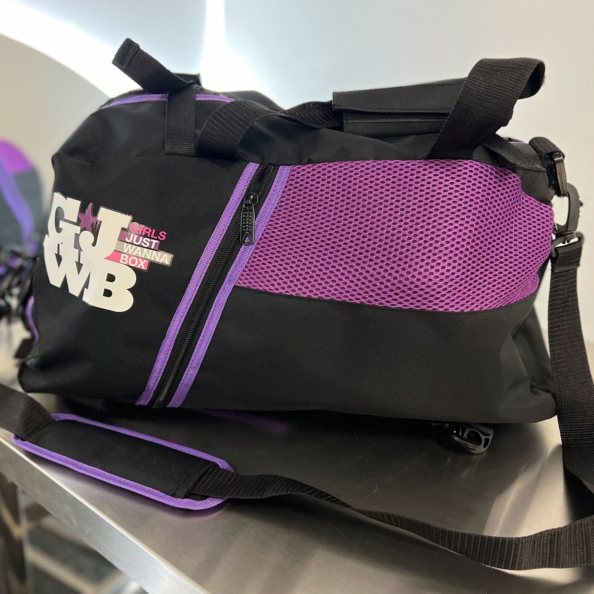 purple and black gym bag on a mirrored table