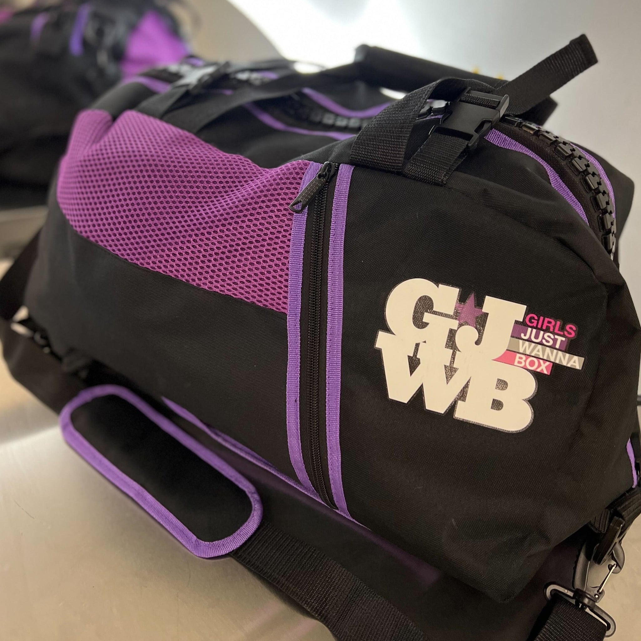 purple and black gym bag on a mirrored table